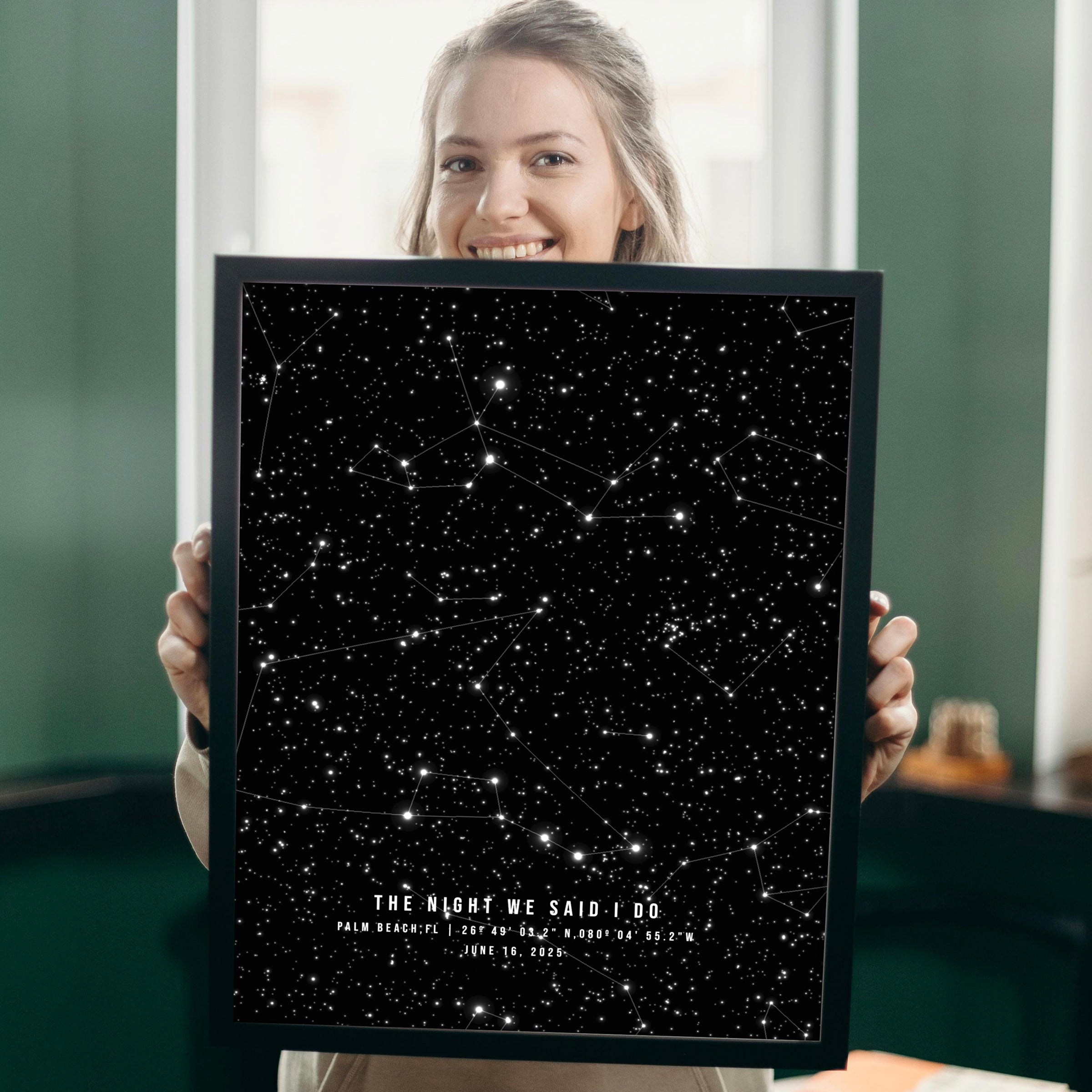 Person holding a framed star map poster with constellations. 1st paper anniversary gift