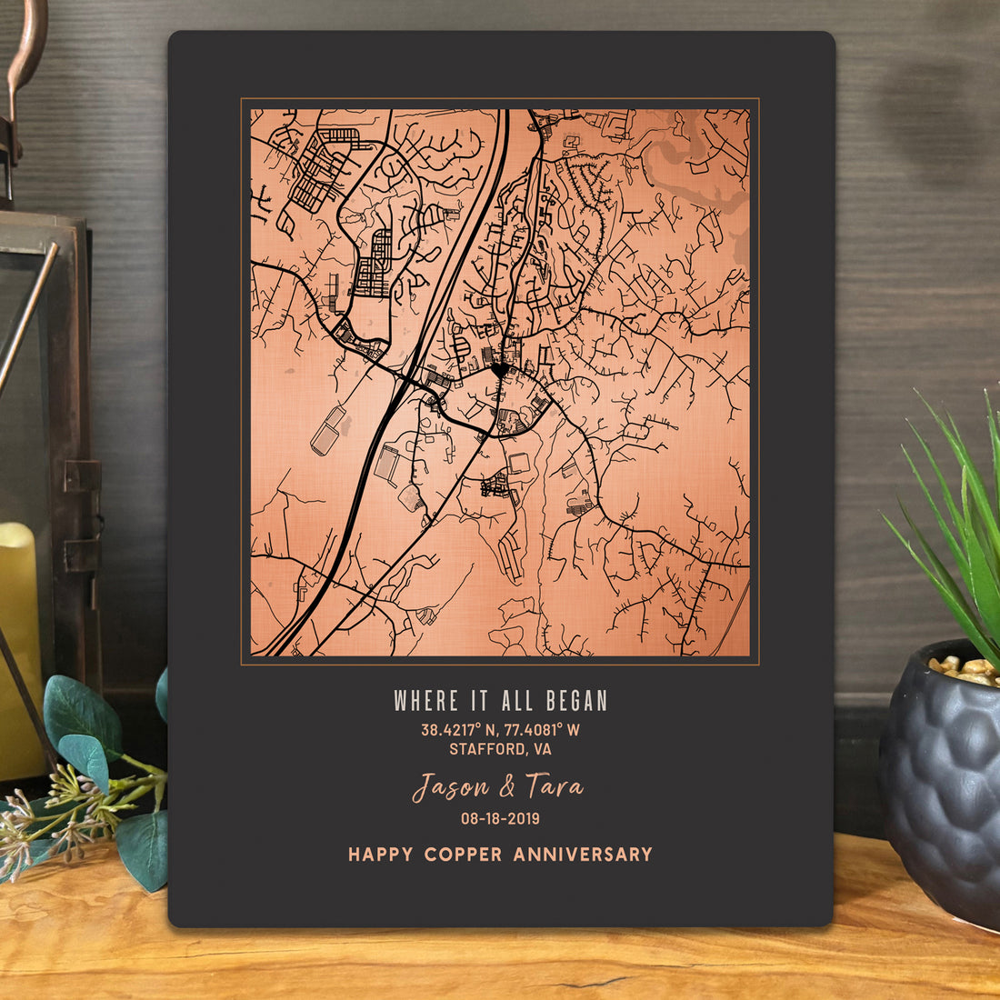 A personalized copper map anniversary print displayed on a metal surface. The black plaque features a copper-toned map of Stafford, Virginia, with the text &