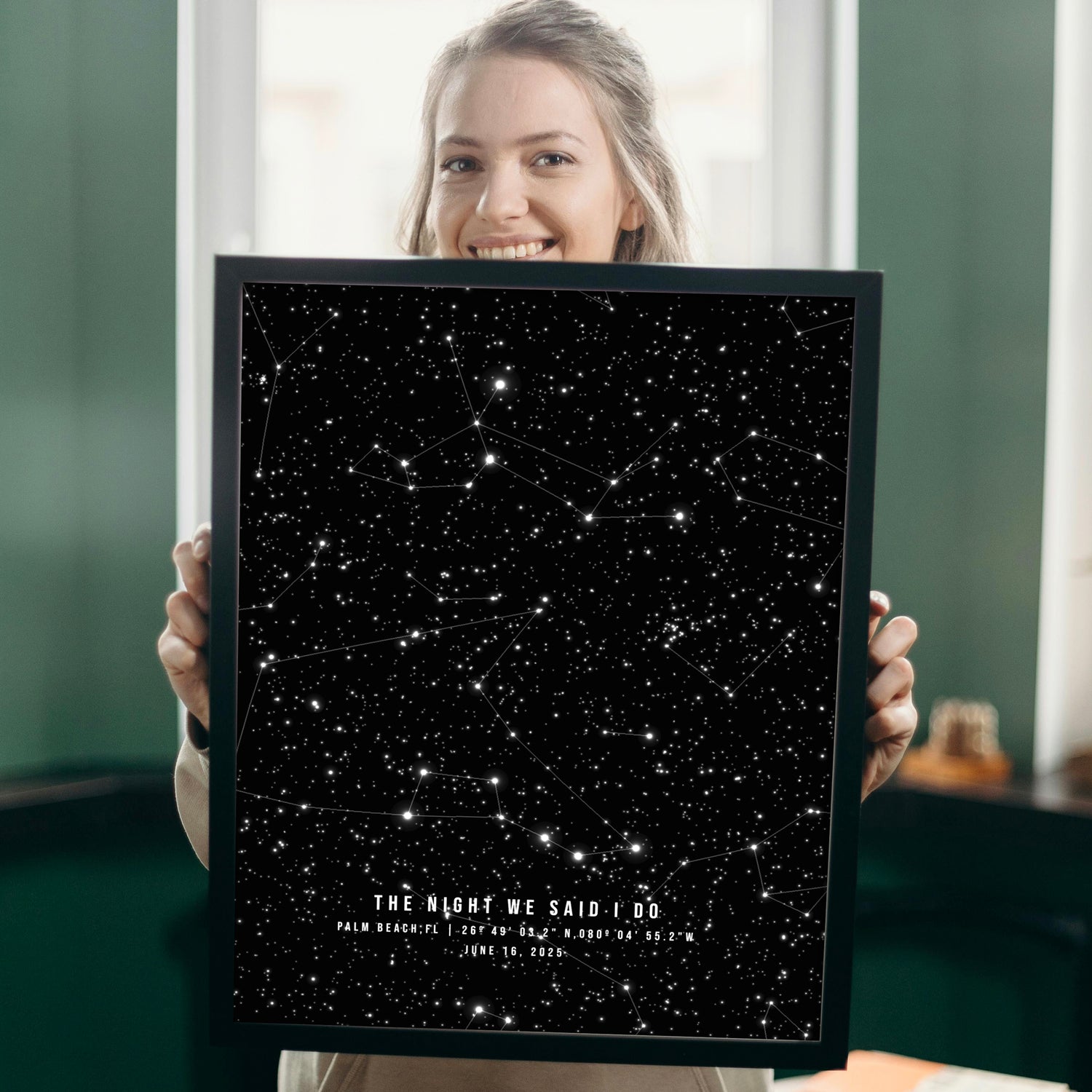 Person holding a framed star map poster with constellations. 1st paper anniversary gift