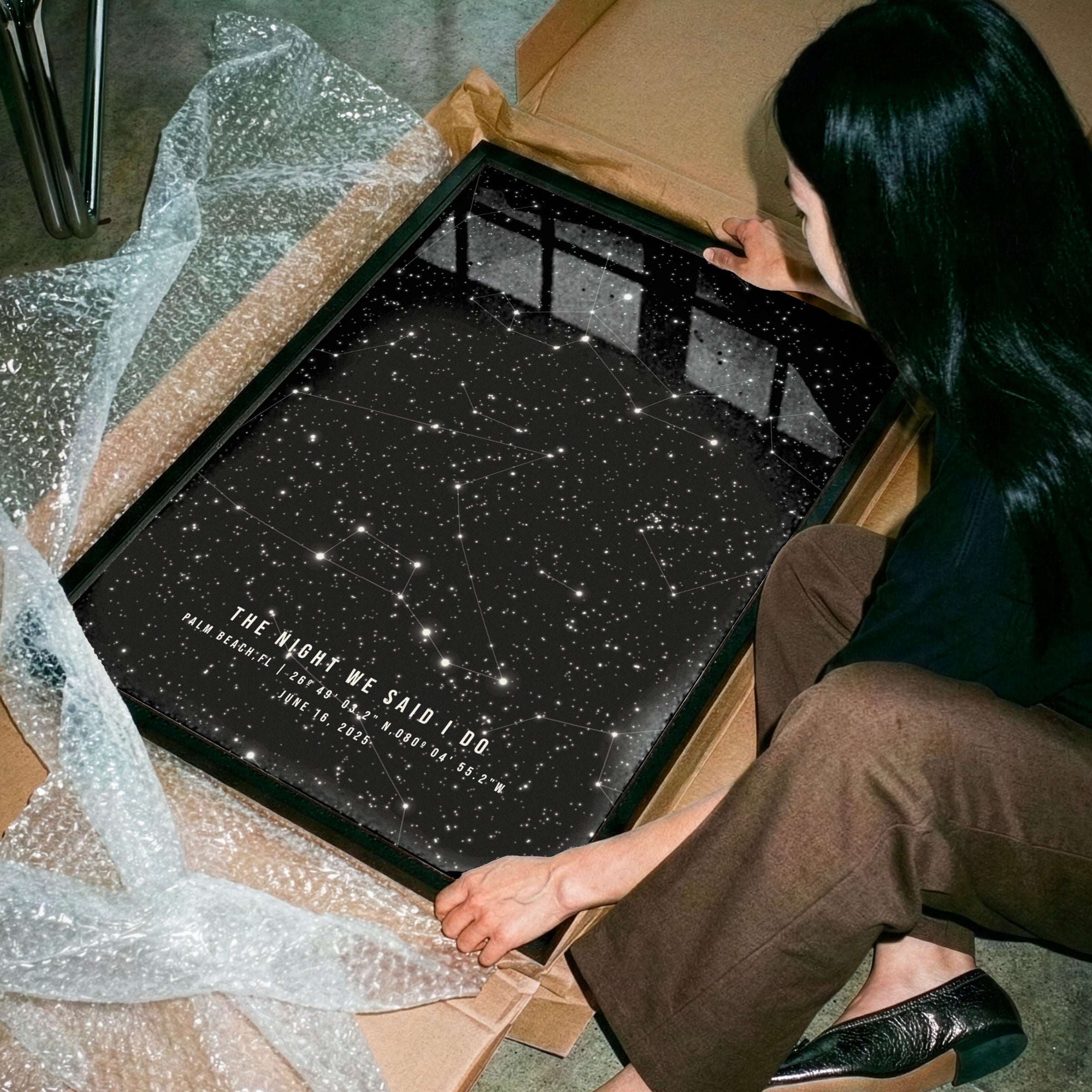 Person opening a box containing a star map with constellations.