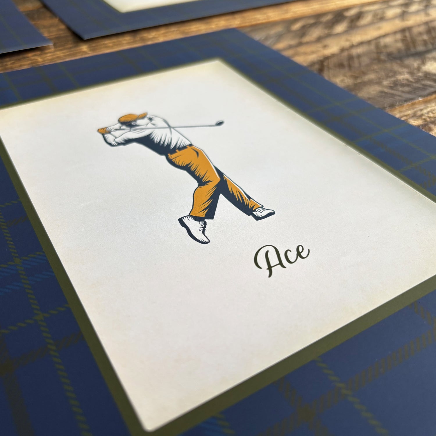 Close-up of vintage-style golfer illustration print with traditional tartan plaid border from the 3-piece golf wall art set. High-quality clubhouse wall decor and thoughtful Father&