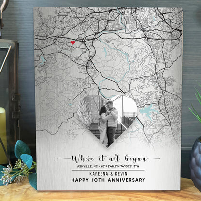 A personalized tin anniversary map canvas print featuring a black and white street map of Asheville, NC with a red heart pinpoint and a heart-shaped cutout showing a couple&