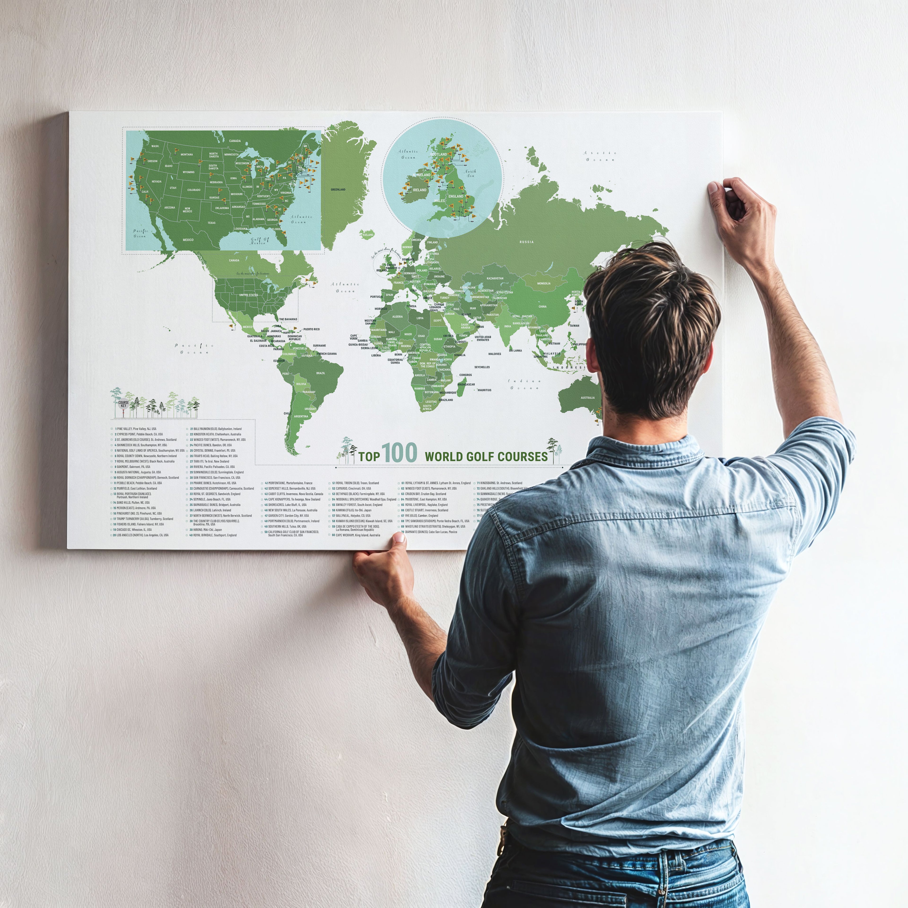 Man adjusting a world map poster on a wall
